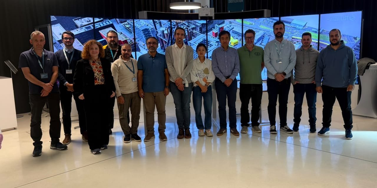 Members of the LATTICE consortium standing in a row in front of a curved wall of display screens at LIST in Esch-sur-Alzette/Belval.